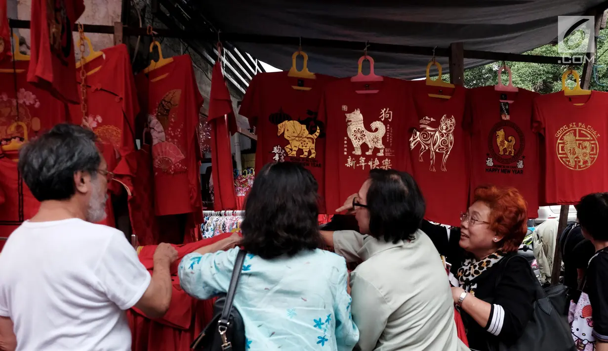 Sejumlah calon pembeli melihat pakaian bertema Imlek yang dijual di kawasan Glodok, Jakarta, Kamis (25/1). Adapun berbagai macam aksesoris yang dijual para pedagang diantaranya lampion, angpao, Sio Anjing, gantungan pintu. (Liputan6.com/JohanTallo)