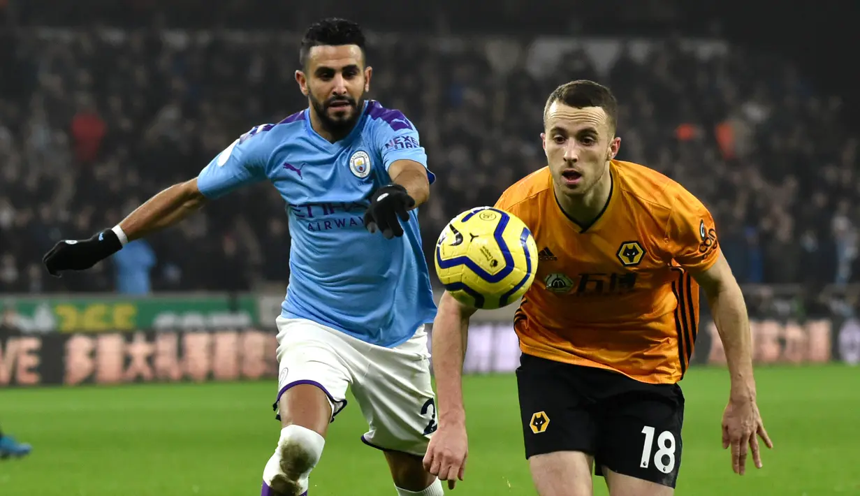 Pemain Manchester City Riyad Mahrez (kiri) berebut bola dengan pemain Wolverhampton Wanderers Diogo Jota pada pertandingan Liga Inggris di Molineux Stadium, Wolverhampton, Inggris, Jumat (27/12/2019). Wolverhampton Wanderers menang 3-2. (AP Photo/Rui Vieira)