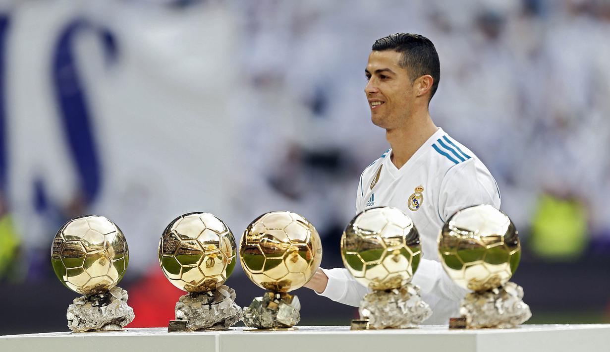 Bintang Real Madrid, Cristiano Ronaldo, berpose dengan kelima trofi Ballon d'Or di Stadion Santiago Bernabeu, Sabtu (9/12/2017). Cristiano Ronaldo meraih Ballon d'Or 2017 setelah unggul dari Lionel Messi dan Neymar. (AP/Francisco Seco)