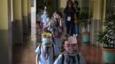Siswa TK dengan masker dan pelindung wajah berjalan pada hari pertama kelas tatap muka di sekolah dasar Comembo di kota Makati, Filipina, Senin (6/12/2021). Beberapa sekolah di Manila diizinkan dibuka kembali setelah berbulan-bulan lamanya karena kasus COVID-19 terus menurun. (AP Photo/Aaron Favila)