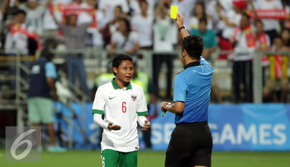 Gelandang Indonesia U-23, Evan Dimas Darmono (kiri) mendapat ganjaran kartu kuning saat laga melawan Myanmar di penyisihan grup A Sea Games 2015 di Stadion Jalan Besar, Singapura, Selasa (2/6/2015). Indonesia kalah 4-2. (Liputan6.com/Helmi Fithriansyah)