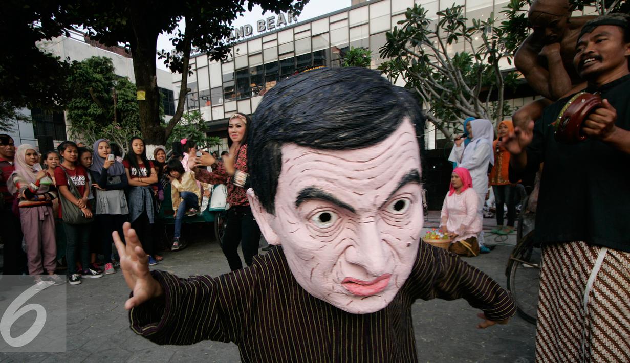 Seorang anak mengenakan topeng MR.Bean pada Jogja Street Sculpture Project di Jalan Mangkubumi , (30/10/15).Sejumlah karya seni patung di paang di ruang publik yang di ikuti oleh 32 pematung. (Foto /Boy T Harjanto)