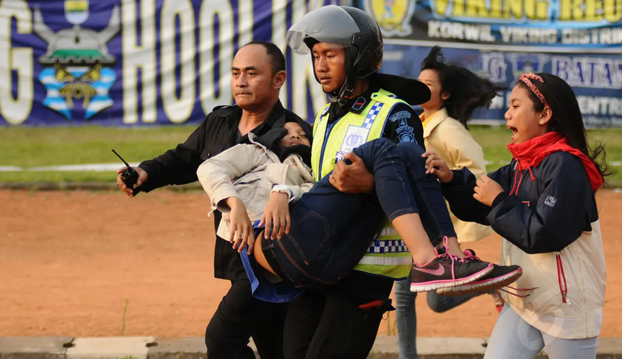 Salah satu suporter wanita Persib Bandung terlihat pingsan dan harus dievakuasi petugas di Stadion Si Jalak Harupat, (10/6/2014). (Liputan6.com/Helmi Fithriansyah)