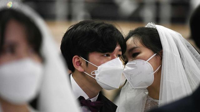 Peserta pernikahan massal di Korea Selatan terpaksa mengenakan masker guna mengantisipasi penyebaran Virus Corona. (Source: AFP)