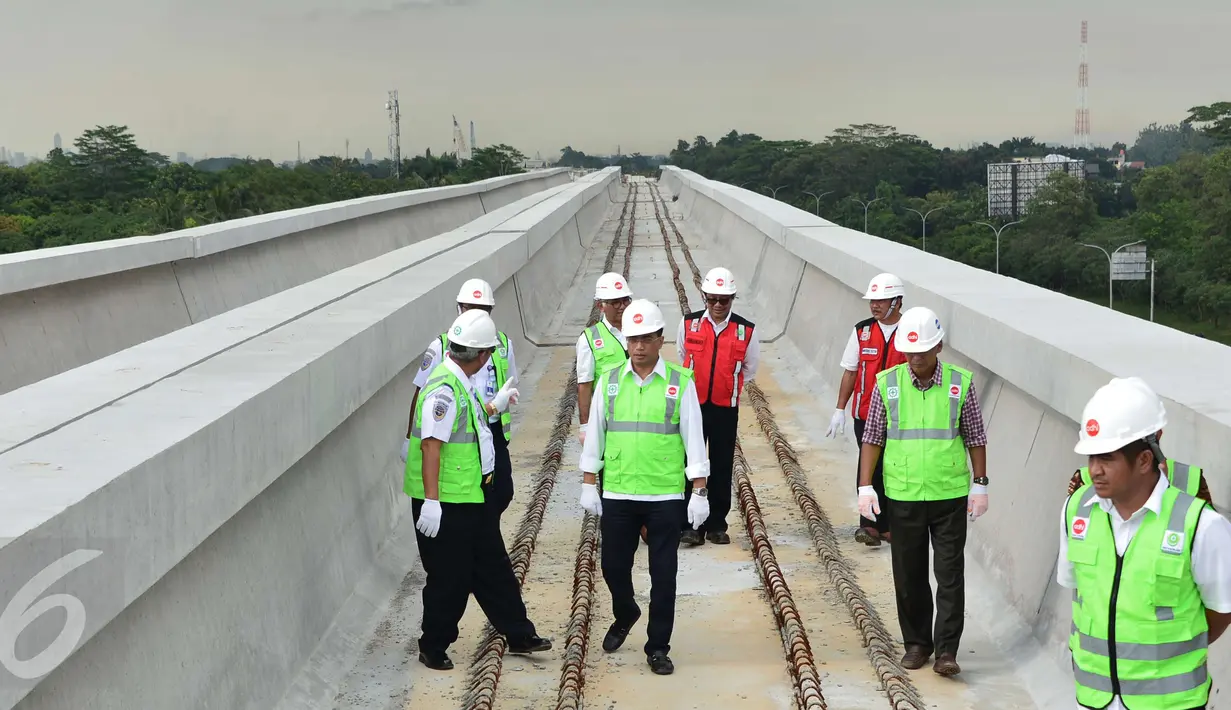 Menteri Perhubungan Budi Karya Sumadi mengecek pemasangan lintasan kereta dari atas lokasi LRT rute Cawang-Cibubur di tol Jagorawi Km 13, Jakarta, Minggu (8/1). Proyek LRT tahap 1 Cibubur-Cawang baru selesai 15 persen. (Liputan6.com/Helmi Afandi)