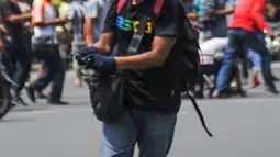 Terlihat seorang pria membawa senjata di Jalan Thamrin, Jakarta, Kamis (14/1). Dari foto, terlihat seorang pria berkaos hitam, topi hitam dan memakai sarung tangan tengah memegang senjata api. (REUTERS/Veri Sanovri/Xinhua)