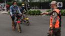 Satpol PP menghentikan pesepeda yang tidak mengenakan masker dengan benar di kawasan Bundaran HI, Jakarta, Minggu (17/1/2021). Pemerintah terus melakukan berbagai upaya guna mencegah penyebaran COVID-19 dan menurunkan angka masyarakat yang terpapar virus corona. (Liputan6.com/Johan Tallo)