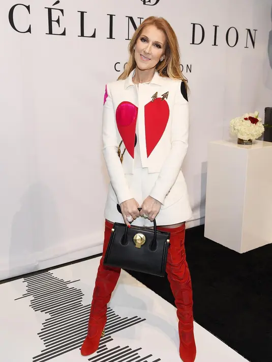 Celine Dion dalam balutan outfit dari Schiaparelli. Gaya cute dengan setelan structured jacket bermotif hati merah dan mini skirt yang kemudian dipadukan dengan high boots merah, Celine Dion terlihat elegan memesona. Foto: Instagram.