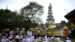 Umat Hindu berdoa untuk merayakan Hari Raya Galungan di Pura Jagat Natha di Denpasar, di pulau Bali (16/9/2020). Galungan dirayakan umat Hindu di Bali sebagai hari kemenangan Dharma (Kebaikan) melawan Adharma (Keburukan). (AFP Photo/Sonny Tumbelaka)