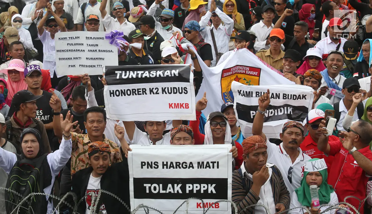 Ribuan honorer K2 seluruh Indonesia berunjuk rasa di depan Istana Merdeka, Jakarta, Selasa (30/10). Mereka meminta Presiden Joko Widodo segera mengambil keputusan mengangkat semua honorer K2 menjadi Pegawai Negeri Sipil (PNS). (Liputan6.com/Angga Yuniar)
