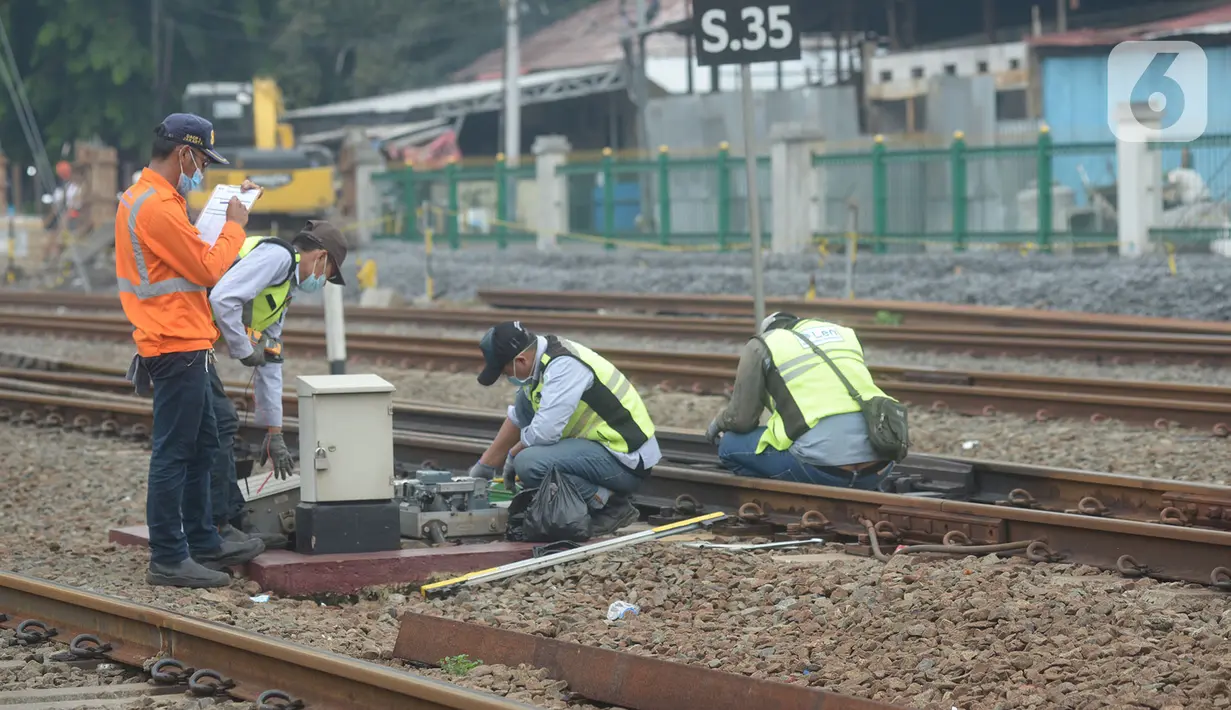 Petugas melakukan pengecekan wesel di perlintasan kereta api Cipinang-Jatinegara, Jakarta, Kamis (5/11/2020). Pengecekan perlintasan secara berkala di lakukan KAI untuk mengurangi potensi kecelakaan kereta api. (merdeka.com/Imam Buhori)