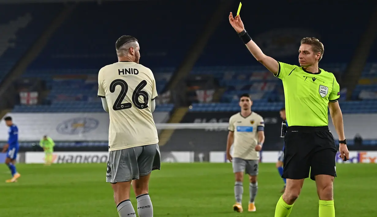Bek AEK Athens, Nassim Hnid, menerima kartu kuning dari wasit Lawrence Visser, dalam laga lanjutan Liga Europa 2020/21 Grup G melawan Leicester City di King Power Stadium, Kamis (10/12/2020). AEK Athens kalah 0-2 dari Leicester City. (AFP/Ben Stansall)