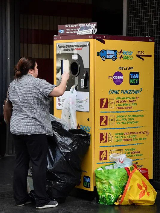 Calon penumpang menukarkan sampah botol plastik dengan tiket kereta menggunakan mesin daur ulang di stasiun metro bawah tanah Cipro, Roma, Selasa (8/10/2019). Program penukaran botol plastik dengan tiket di tiga stasiun kereta bawah tanah kota Roma ini dimulai sejak Juli lalu. (Tiziana FABI/AFP)