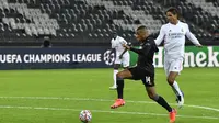 Pemain Borussia Monchengladbach, Alassane Plea membawa bola dari kawalan bek Real Madrid, Raphael Varane  pada pertandingan grup B Liga Champions di  Borussia Park, Jerman, Selasa (27/10/2020). Madrid bermain imbang 2-2 atas Monchengladbach. (AP Photo/Martin Meissner)