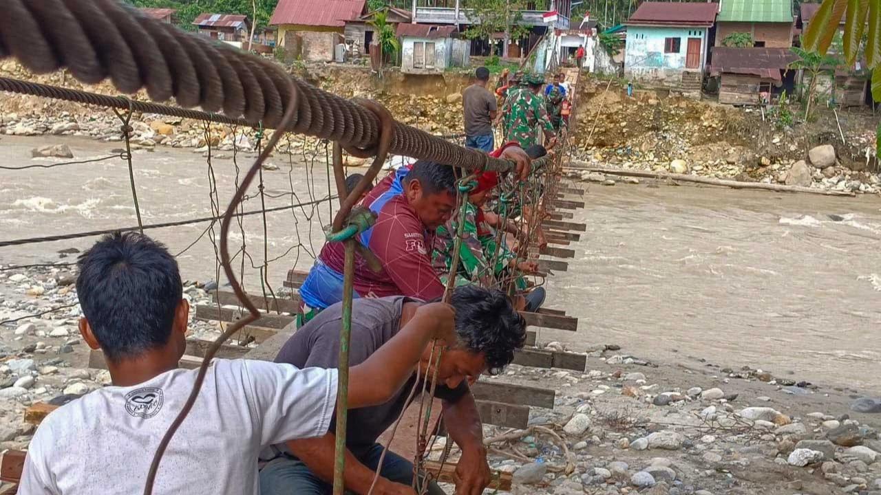 FOTO: Gotong Royong  Prajurit TNI AD dan Warga Perbaiki Jembatan Gantung di Aceh Tenggara