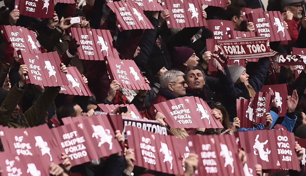 Suporter Torino membawa banner saat mendukung timnya melawan Juventus pada laga Serie A  di Stadio Grande Torino, Turin (18/2/2018). Juventus menang 1-0. (AFP/Marco Bertorello)