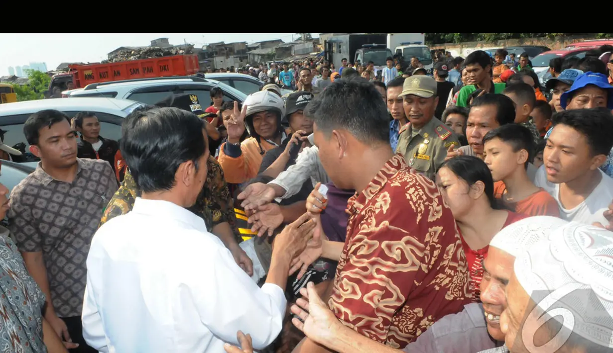 Pada kesempatan itu Jokowi, sapaan Joko Widodo, membagikan beras dan uang kepada warga sebagai Tunjangan Hari Raya (THR) Lebaran, Jakarta, Kamis (24/7/2014) (Liputan6.com/Herman Zakharia)
