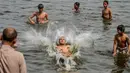 Pria dan anak muda Pakistan mendinginkan diri ke perairan Laut Arab saat musim panas di Karachi pada 5 Juli 2020. Mereka menghabiskan hari yang cerah dengan berenang di tengah pandemi virus corona. (Photo by Rizwan TABASSUM / AFP)