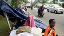 Para pencari suaka berteduh di bawah terpal di trotoar depan Rumah Detensi Imigrasi Kalideres, Jakarta, Jumat (19/1). Para pencari suaka berasal dari Afghanistan, Sudan, dan Somalia. (Liputan6.com/JohanTallo)
