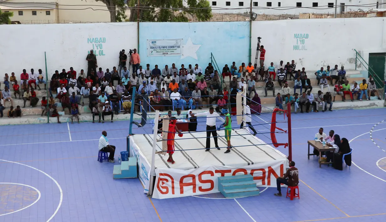 Petinju Somalia bertanding di atas ring di Stadion Wish, Mogadishu pada 15 November 2018. Ketika pertandingan adu jotos ini pertama kali diadakan kembali, warga tampak antusias menanti pertandingan demi pertandingan. (Abdirazak Hussein FARAH / AFP)