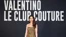 Anne Hathaway tampil roar dengan mini dress dan stocking motif macan. Look tersebut dari koleksi Pre Fall 23. Ia juga membawa Valentino Garavani Loco’ tas dan heelsnya. Credit: Valentino/SGP Italia
