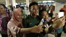 Warga mengajak selfie pemain Timnas Indonesia, Bagas Adi, usai menjadi juara Piala AFF U-22 2019 di Bandara Soetta, Tanggerang, Rabu (27/2). Timnas Indonesia mendapatkan bonus sebesar 2,1 milliar rupiah dari Kemenpora. (Bola.com/Yoppy Renato)