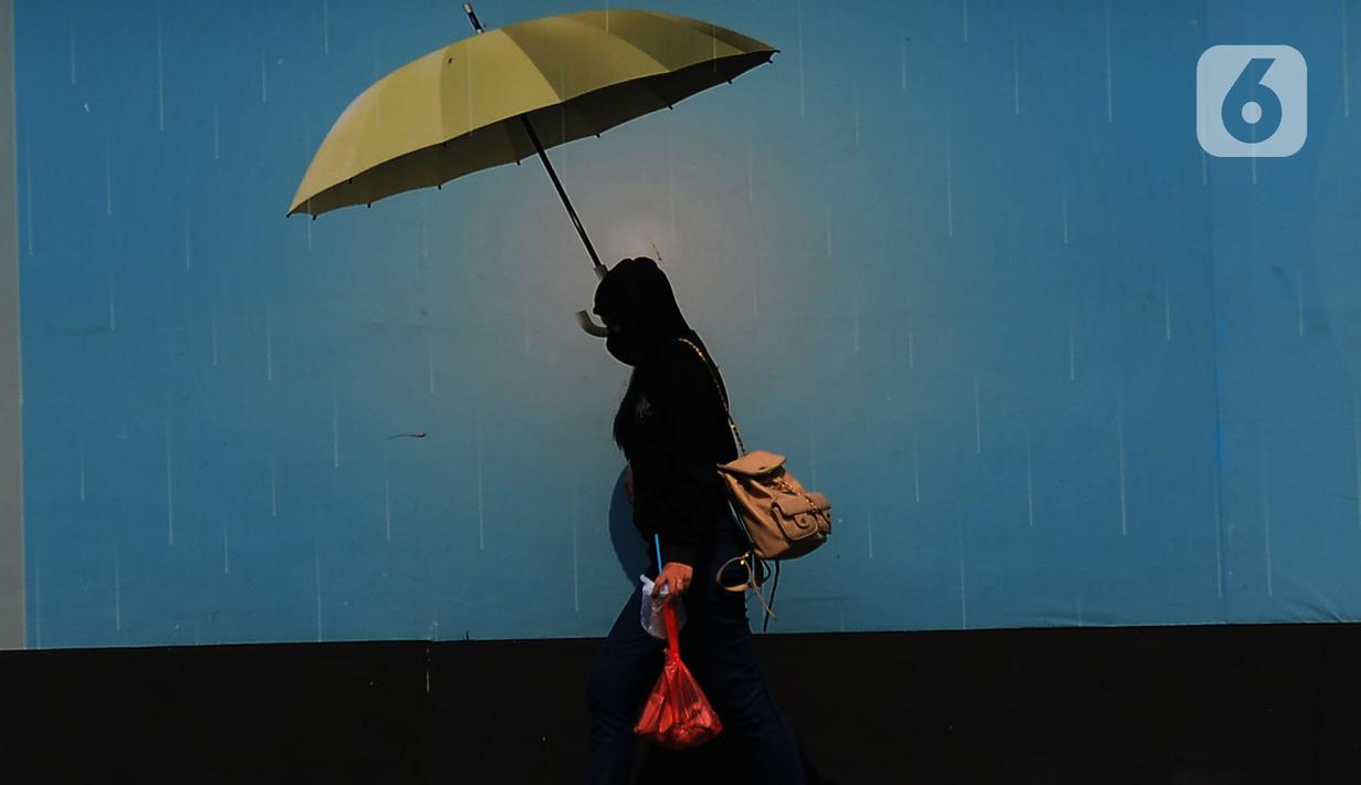 Pejalan kaki mengenakan payung untuk menghindari panas matahari di kawasan Kuningan, Jakarta, Selasa (26/9/2023). (merdeka.com/Imam Buhori)