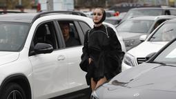 Seorang model berjalan melewati mobil saat drive-in fashion show bagian dari Praha Fashion Week di Praha, Republik Ceko, Sabtu (1/5/2021). Karena pembatasan virus corona, penonton hanya dapat melihat pertunjukan dari dalam mobil mereka. (AP Photo/Petr David Josek)