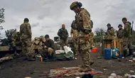 Seorang tentara Ukraina berdiri di atas bendera Rusia di Izium, wilayah Kharkiv, Ukraina, 13 September 2022. Pasukan Rusia tampak meninggalkan Kota Izium dan Svatove di Luhansk usai pasukan Ukraina memulai serangan baru ke arah timur melalui Kharkiv. (AP Photo/Kostiantyn Liberov)