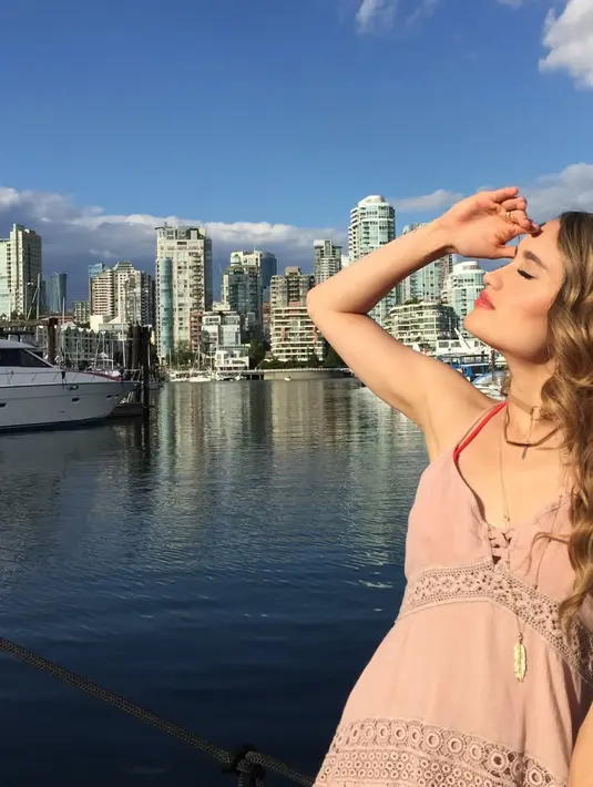 Cinta Laura mengenakan kalung choker warna gold dipadukan atasan spaghetti strap warna pink. Rambut panjang blondenya ditata wavy. [@claurakiehl]