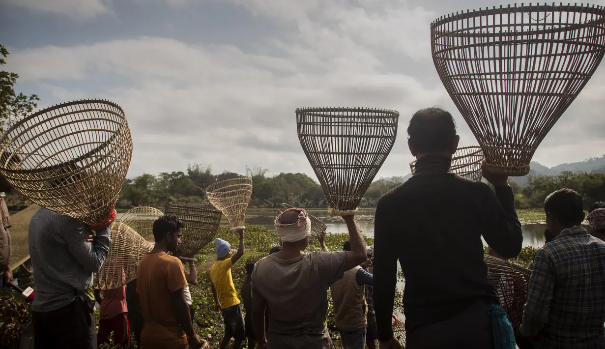 Penduduk desa tiba untuk berpartisipasi dalam komunitas memancing sebagai bagian dari perayaan Bhogali Bihu di desa Panbari, sekitar 50 km timur Gauhati, India, Kamis (13/1/2022). "Bhogali Bihu" menandai berakhirnya musim panen di timur laut negara bagian Assam. (AP Photo/Anupam Nath)