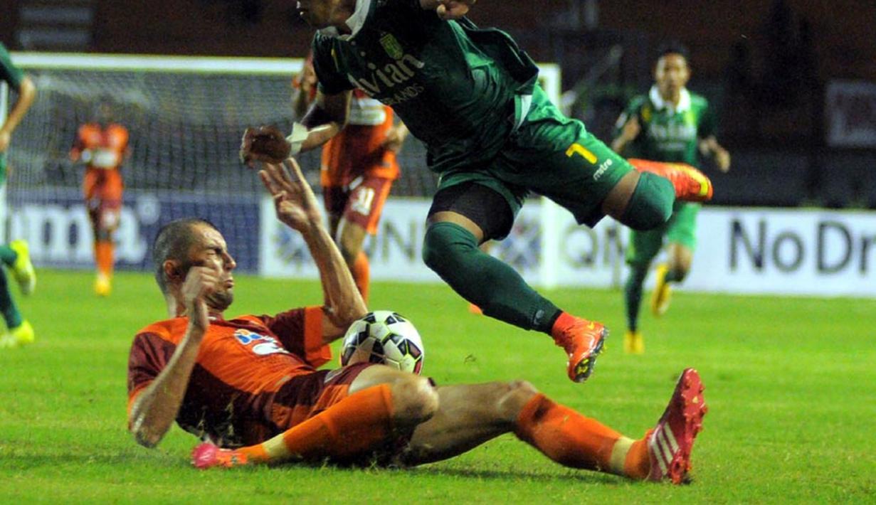 Winger Persebaya Siswanto harus melompat untuk menghindari tekel bek jangkung Pusamania Martin Kovachev. (Liga Indonesia)