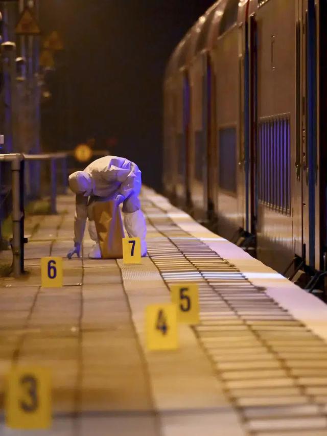 Staf forensik di peron lokasi penikaman fatal dua orang di kereta api di Jerman utara, sesaat sebelum kereta regional yang berangkat dari Kiel ke Hamburg tiba di stasiun Brokstedt. (Jonas Walzberg/AP)