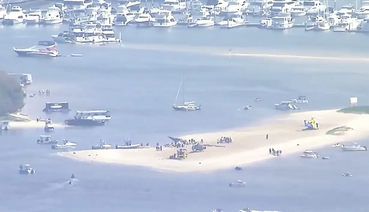 Gambar yang diambil dari video ini menunjukkan pulau pasir dengan helikopter yang jatuh, korban dan layanan darurat di Gold Coast, Australia Senin, 2 Januari 2023. Dua helikopter bertabrakan di hotspot wisata Australia Senin sore. (CH9 via AP)