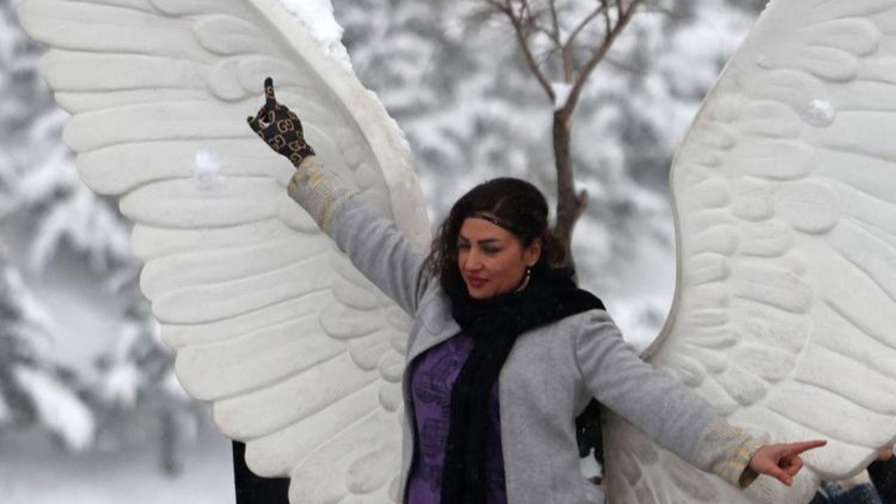Turunnya salju di Iran ini juga membuat warga Iran terkejut sekaligus bahagia karena mereka dapat menikmati pemandangan yang indah.<br>(Foto ATTA KENARE / AFP)<br>