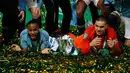 Gelandang dan kiper Manchester City, Raheem Sterling dan Ederson berbaring di dekat trofi setelah memenangkan final Piala Liga Inggris melawan Chelsea di Wembley, Minggu (24/2). Manchester City berhasil menjadi juara Piala Liga Inggris (Adrian DENNIS/AFP)