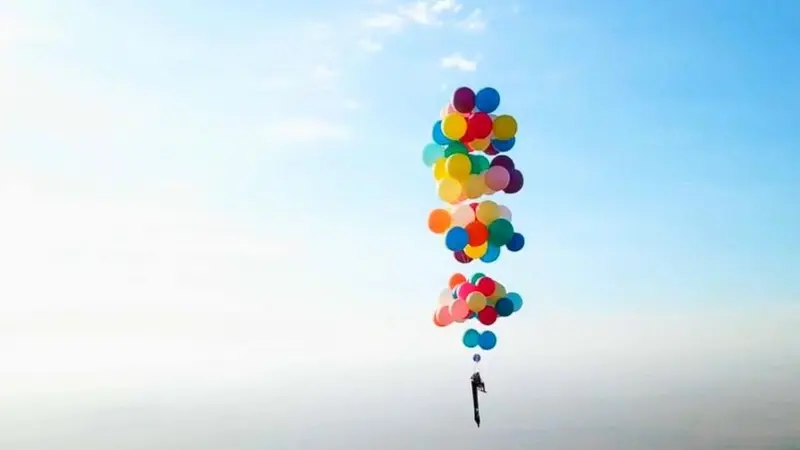 Tom Morgan terbang dengan bermodalkan ratusan balon helium berwarna warni.