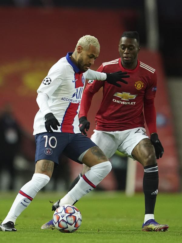 Penyerang Paris Saint Germain (PSG), Neymar berusaha menahan bek Manchester United atau MU, Aaron Wan-Bissaka pada matchday kelima Grup H Liga Champions di Stadion Old Trafford, Kamis (3/12/2020) dinihari WIB. MU keok 1-3 dari PSG. (AP Photo/Dave Thompson)
