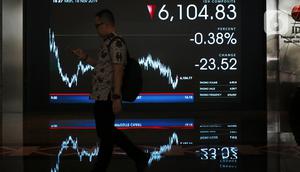 Pekerja tengah melintas di layar pergerakan IHSG di Bursa Efek Indonesia, Jakarta, Senin (18/11/2019). Indeks Harga Saham Gabungan (IHSG) ditutup pada zona merah pada perdagangan saham awal pekan ini IHSG ditutup melemah 5,72 poin atau 0,09 persen ke posisi 6.122,62. (Liputan6.com/Angga Yuniar)