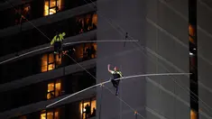 Aerialists Nik Wallenda (kanan) dan saudara perempuannya Lijana Wallenda melintasi seutas kawat di ketinggian 396 meter, Times Square, New York, AS, Minggu (23/6/2019). Aksi berbahaya ini bertajuk Highwire Live In Times Square. (AP Photo/Jason Szenes)