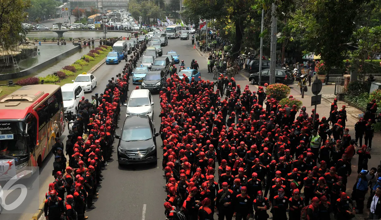 Ribuan buruh berjalan menuju bundaran Istana Merdeka, Jakarta, Jumat (30/10/2015). Aksi tersebut menimbulkan kemacetan lalu lintas kendaraan di sekitar kawasan Istana Negara. (Liputan6.com/Gempur M Surya)