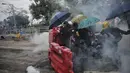 Sejumlah siswa menggunakan payung berlindung di belakang barikade selama bentrokan dengan polisi di Universitas China di Hong Kong (12/11/2019). Ketapel hingga panahan digunakan para demonstran Hong Kong sebagai senjata saat unjuk rasa yang telah berlangsung selama lima bulan. (Steve Leung/HK01 via