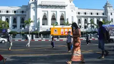 Orang-orang berjalan melewati Balai Kota sehari setelah militer Myanmar merebut kekuasaan, Yangon, Myanmar, Selasa (2/2/2021). Militer Myanmar menahan pemimpin yang terpilih secara demokratis Aung San Suu Kyi dan memberlakukan keadaan darurat satu tahun. (STR/AFP)