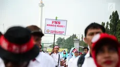 Seorang massa membawa poster dalam aksi damai di depan Istana Negara, Jakarta, Rabu (19/7). Mereka mendesak agar para pegawai non PNS yang telah mengabdi pada garda depan pelayanan publik, bisa diangkat menjadi PNS. (Liputan6.com/Faizal Fanani)