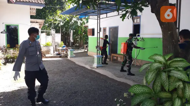 Aparat Keamanan TNI-Polri Melakukan Penyemprotan Desinfektan  di SDN  03 Wonorejo Situbondo Pasca 6 Siswa Dinyatakan Positif Covid-19. (Hermawan Arifianto/Liputan6.com)