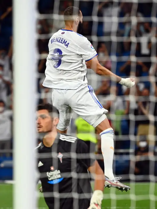 Pemain Real Madrid Karim Benzema melakukan selebrasi usai mencetak gol ke gawang Celta Vigo pada pertandingan Liga Spanyol di Stadion Santiago Bernabeu, Madrid, Spanyol, 12 September 2021. Karim Benzema mencetak hattrick saat Real Madrid mengalahkan Celta Vigo 5-2. (GABRIEL BOUYS/AFP)