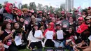 Ketua Nasional Relawan Tim Alpha Jokowi-Ma'ruf Amin, Rieke Diah Pitaloka (tengah) bersama pekerja migran menunjukkan surat deklarasi Tim Zona Alpha Hongkong mendukung pasangan Jokowi-Ma'aruf Amin di Hongkong, Minggu (23/9). (Liputan6.com/HO/Tim Alpha)