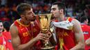 Pebasket Spanyol, Juan Hernangomez (kanan) dan Willy Hernangomez mencium trofi Piala Dunia Basket 2019 setelah mengalahkan Argentina pada laga final yang berlangsung di Beijing, China, 15 September 2019. Juan Hernangomez merupakan adik dari Willy Hernangomez. Kombinasi pasangan kakak beradik ini membuat frontcourt Timnas Spanyol solid. Juancho Hernangomez sendiri merupakan pemain Toronto Raptors di NBA pada musim lalu. (AFP/Greg Baker)