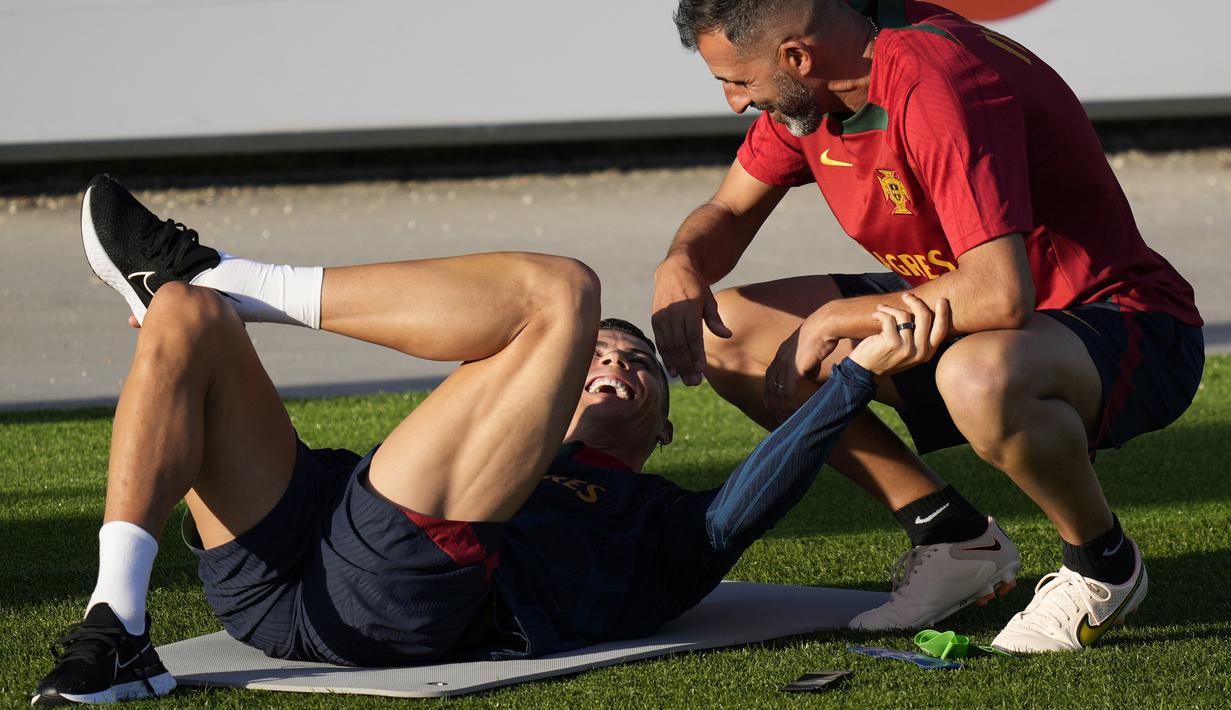 Pemain Portugal, Cristiano Ronaldo, berbincang dengan pelatih kiper Ricardo saat mengikuti sesi latihan jelang menghadapi laga Kualifikasi Euro 2024 di Lisbon, (20/3/2023). Portugal akan menjalani laga kualifikasi Euro 2024. (AP Photo/Armando Franca)