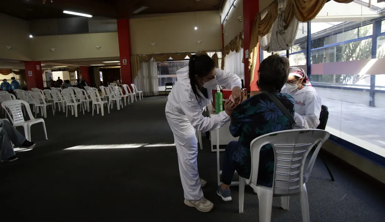 Seorang perempuan mendapat suntikan vaksin COVID-19, di Quito, Ekuador, Kamis (24/12/2021). Pemerintah Ekuador telah menyatakan vaksinasi COVID-19 wajib setelah meningkatnya infeksi dan munculnya varian baru virus corona. (AP Photo/Carlos Noriega)